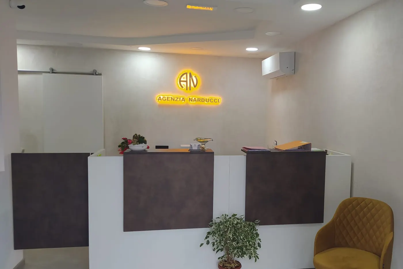 La reception dell'Agenzia Narducci, con il logo illuminato sulla parete